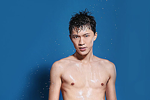 蓝色背景下面容清爽的亚洲男青年