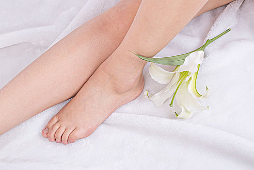 美丽光滑的女性脚部和百合花