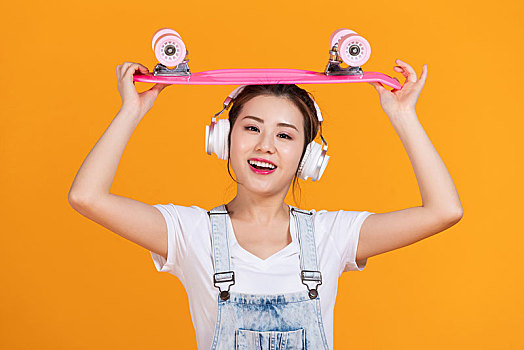 棚拍拿著滑板的年輕女子