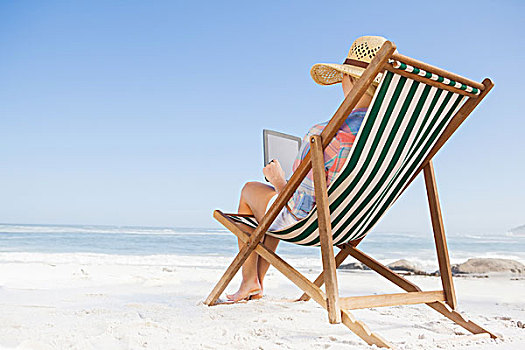 女人,太阳帽,坐,海滩,折叠躺椅,平板电脑