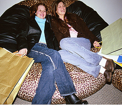 两个女人,坐,豆袋椅,购物袋
