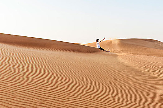 少男,坐,荒漠沙丘,投掷,沙子,空中