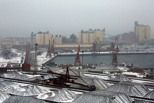 山东省日照市,狂风暴雪席卷港城,港口生产受阻,红色矿石堆场变身,雪山