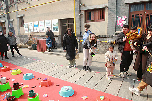 春节庙会热闹非凡,外国美女玩套圈游戏体验中国年