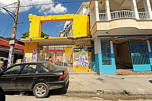 haiti,port,au,prince,4x4,car,parked,in,front,of,ruined,commercial,building