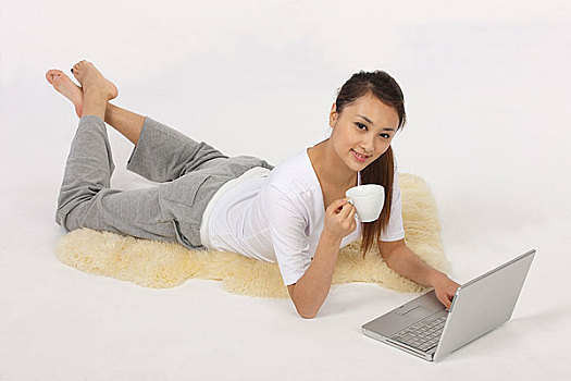 年轻女人喝咖啡使用笔记本电脑