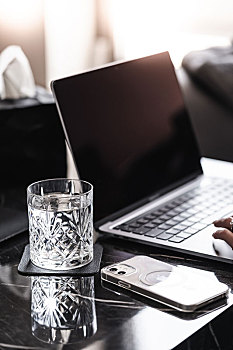 阳光明媚的午后,白领们惬意的泡上一杯咖啡,在现代简洁的办公桌上,使用笔记本电脑和手机办公