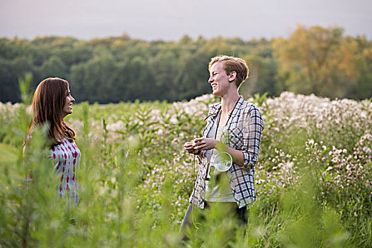 两个女人,站立,草地,围绕,高草,野花