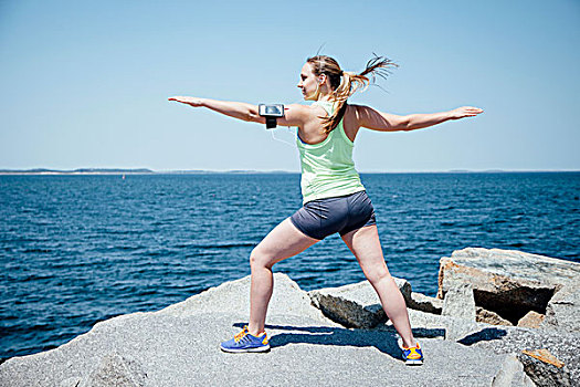 全身,后视图,女人,穿,活动,岩石上,海洋,展开双臂,练习
