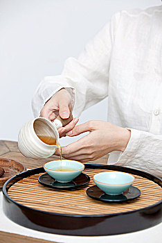 一个东方女性茶艺师倒茶局部特写