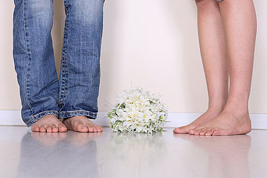 一对男女的脚旁放着一束鲜花