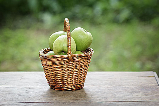 青苹果,柳条篮,木桌子