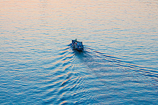 夕阳中驶向远方的渔船