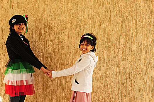 kuwait,city,portrait,of,2,smiling,girls,taking,hands,and,disguised,with,kuweiti,flag