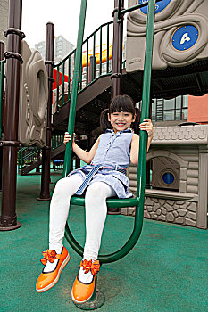 小女孩在幼儿园内玩滑梯