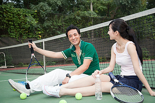 坐在网球场休息的年轻人