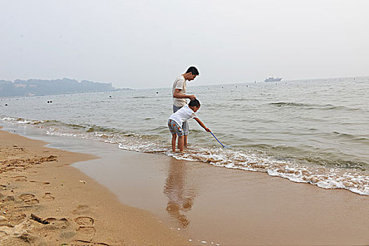 夏日大海边游玩的父子