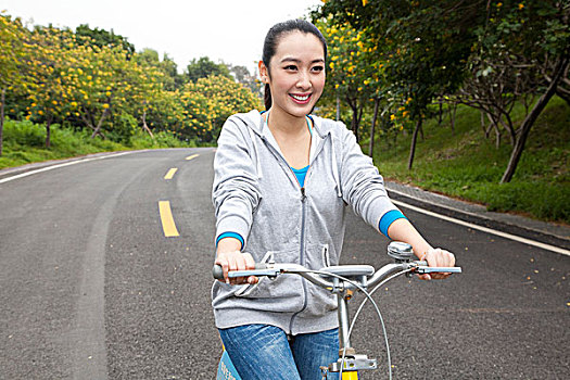 一个年轻女大学生在校园里骑车