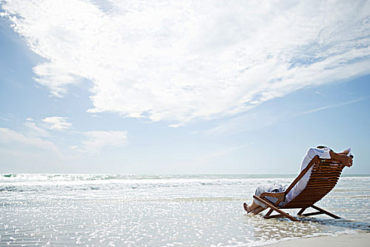 男人,坐,折叠躺椅,海滩,海浪,洗,后视图