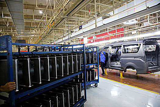 重庆民生物流公司汽车员工正在汽车生产线上用电瓶车运送汽车零部件