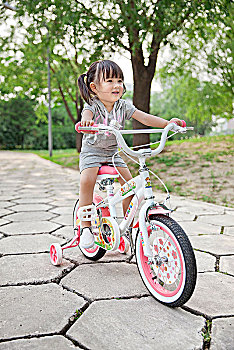 正在骑自行车的小女孩