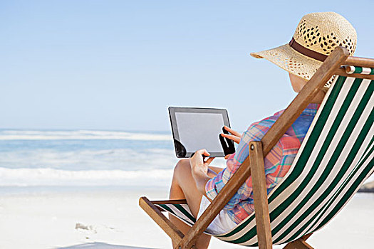 女人,太阳帽,坐,海滩,折叠躺椅,平板电脑