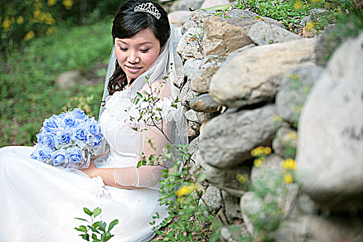 坐在石头墙前的新娘