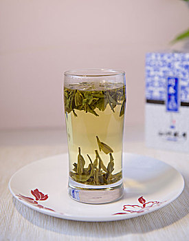 一盒青花铁盒包装的西湖龙井茶和茶饮