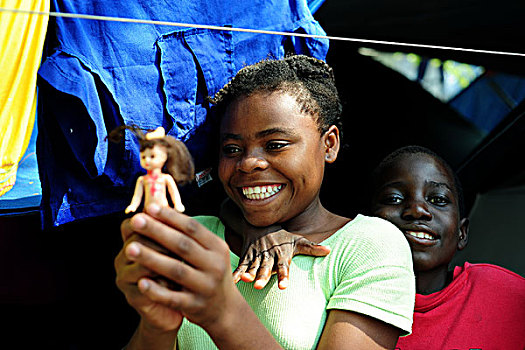 haiti,port,au,prince,two,black,girls,playing,with,puppet,in,refugee,camp