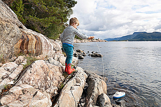 男孩,站立,石头,峡湾,玩,玩具船,挪威