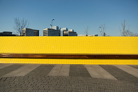 城市基础设施路旁的黄色休息长椅