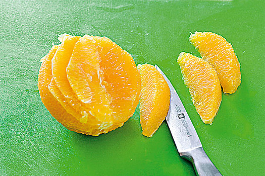 特写,橙子片,刀,绿色背景