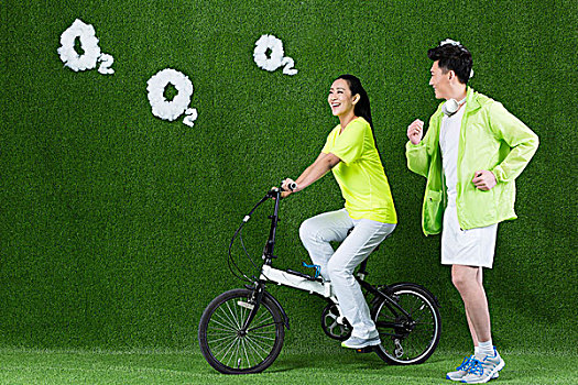 草地創意年輕情侶騎自行車