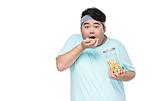 肥胖的年轻男子吃爆米花