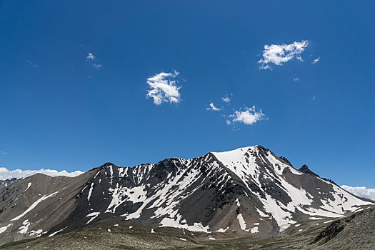 中国新疆夏季蓝天白云下g217独库公路沿途雪山草地