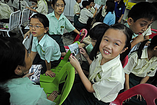 malaysia,kuala,lumpur,children,looking,at,photographs,in,the,classroom