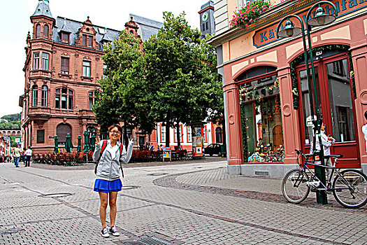 一名女性站在德国海德堡的古典建筑前