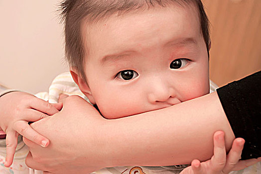 一名7个月大的男婴抓着母亲的胳膊吸吮