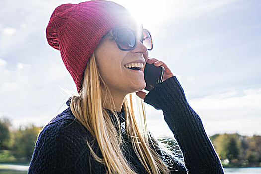 美女,戴着,红色,编织帽,湖岸,交谈,智能手机