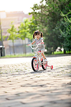正在骑自行车的小女孩
