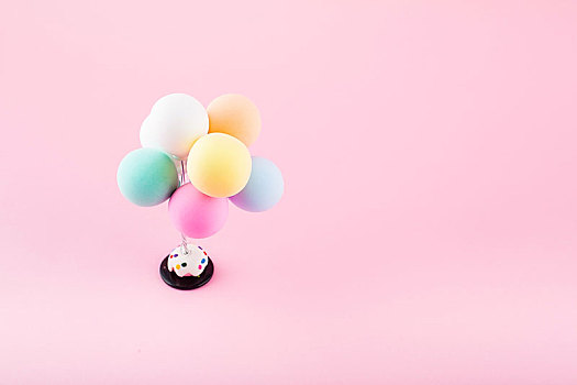 彩色的气球放在粉色的背景纸上