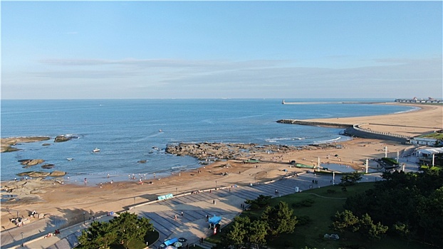 秋日里的海滨风景如画,游客赶海拾贝感受惬意周末