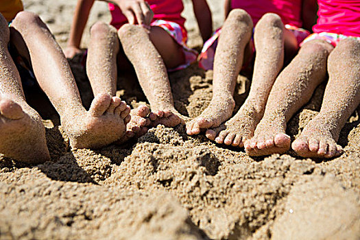 沙,覆盖,腿和脚,四个孩子
