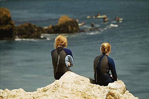 后视图,两个女人,坐,石头,海洋