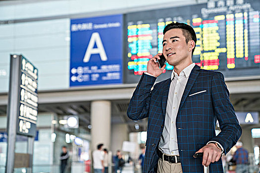 年轻商务男士在机场打电话