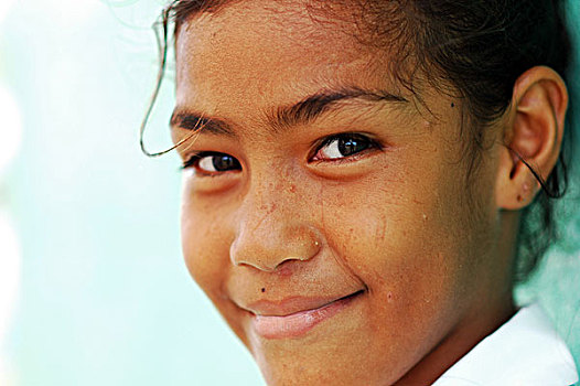 tuvalu,funafuti,close-up,portrait,of,a,girl,smiling,standing,in,front,green,wall