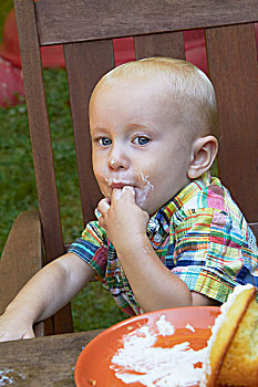 小男孩,舔,浇料,手指,杯形蛋糕