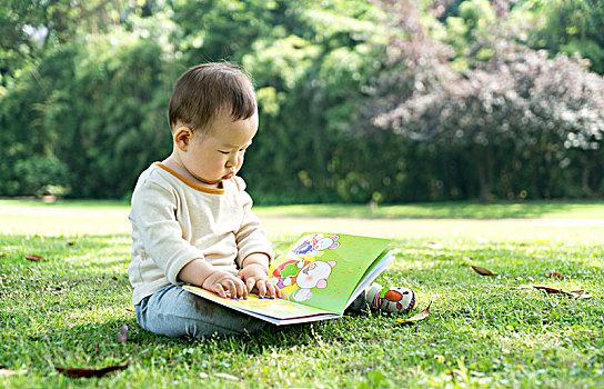 宝宝坐在草地上看书
