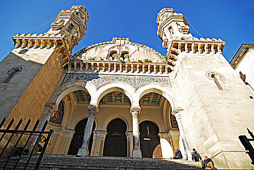 algeria,alger,upward,view,of,a,historic,building,with,columns,cusped,entrance,and,people,sitting,on,steps