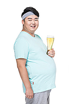 肥胖的年轻男子拿着啤酒